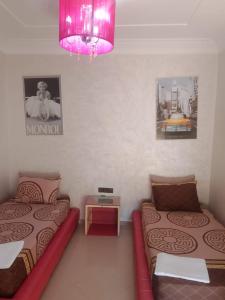 a bedroom with two beds and a pink light at Appartement vu sur Mer in Mohammedia +33 photos