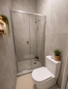 a bathroom with a shower and a toilet in it at Brunsi Hostel in Melbourne +4 photos