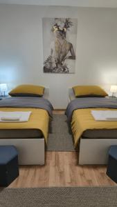a bedroom with two beds and a painting on the wall at InOsijek- FEELS LIKE HOME in Osijek