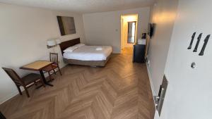 a room with a bed and a table and a desk at Midtown Inn Saskatoon in Saskatoon