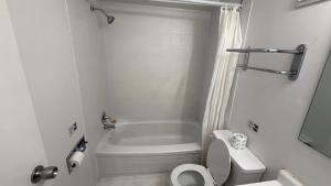 a bathroom with a white tub and a toilet at Midtown Inn Saskatoon in Saskatoon