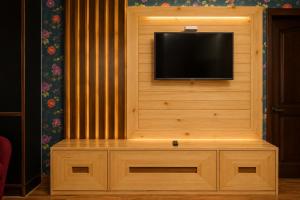 a flat screen tv sitting on top of a wooden wall at Jannat Hotel - Solan in Solan +17 photos