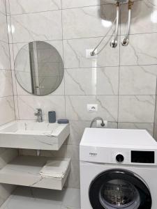 a bathroom with a washing machine and a sink at Adan Luxury Aparthotel in Orikum +28 photos