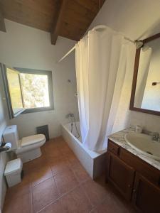a bathroom with a tub and a toilet and a sink at Hotel Guara Inlukā in Las Almunias