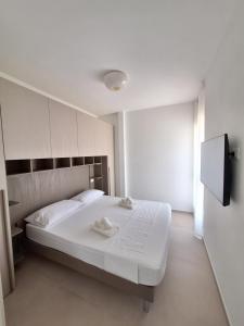 a bedroom with a white bed with towels on it at Onde e Relax D&D in Marina di Bibbona +13 photos