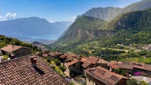 a woman standing on the roof of a village with mountains at Le Orme in Tenno +24 photos