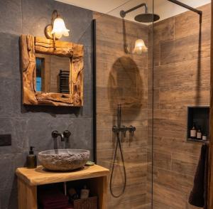 a bathroom with a shower with a sink and a mirror at Le Orme in Tenno