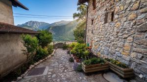 a stone building with plants on the side of it at Le Orme in Tenno