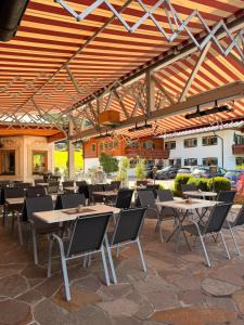 a patio with tables and chairs under a roof at Hotel Bergheimat in Schönau am Königssee