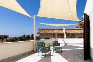 a patio with chairs and a table on a roof at kalispera in Cinisi