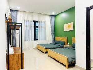 a bedroom with two beds and a green wall at Lala VILLA ĐÀ LẠT in Da Thien +5 photos