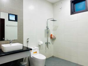 a bathroom with a white toilet and a sink at Lala VILLA ĐÀ LẠT in Da Thien