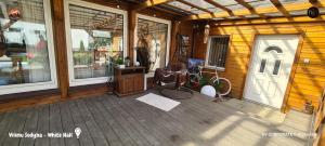 a porch of a wooden cabin with a white door at Vilimu Sodyba - White Hall in Kriukai