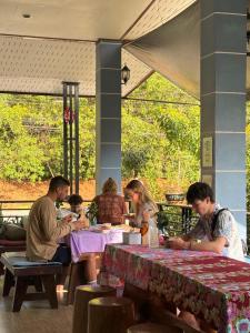 a group of people sitting at tables in a restaurant at Khao Sok Backpacker Hostel in Khao Sok National Park