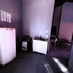 a room with a white refrigerator and a table at Praia de Pitangui in Extremóz