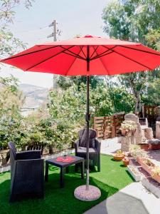 a red umbrella and two chairs and a table at Villa Valeria in San Floro