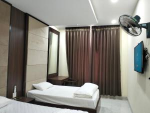 a hotel room with two beds and a mirror at Nhà khách 705 in Mộc Châu +8 photos
