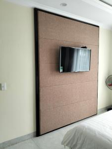 a flat screen tv on a wall in a bedroom at Nhà khách 705 in Mộc Châu