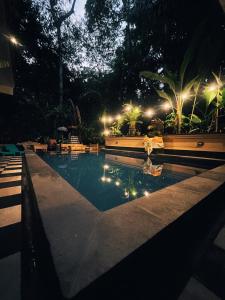a swimming pool at night with lights at The Nest in Ubud in Ubud
