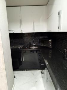 a kitchen with white cabinets and a sink at 19 Rustaveli Ave in Batumi