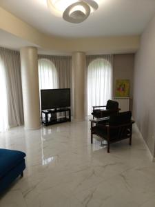 a living room with a flat screen tv and furniture at 19 Rustaveli Ave in Batumi