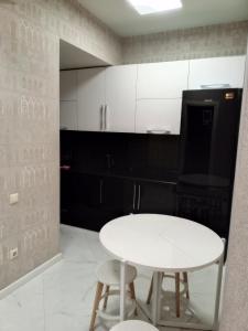 a white table and two stools in a kitchen at 19 Rustaveli Ave in Batumi