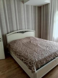 a bed in a room with a striped wall at 19 Rustaveli Ave in Batumi +3 photos