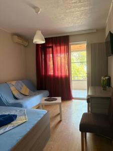 a bedroom with two beds and a red curtain at Apartments President in Star Dojran