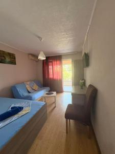 a bedroom with two beds and a desk and a window at Apartments President in Star Dojran