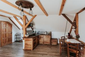a kitchen with wooden cabinets and a table at RANČ JUREŠ - Relaxing Countryside Escape in Ljutomer