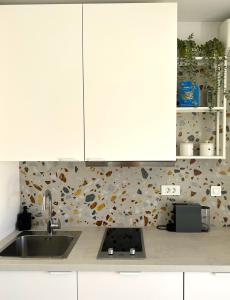 a kitchen with white cabinets and a sink at Apartment Dalmare in Biograd na Moru