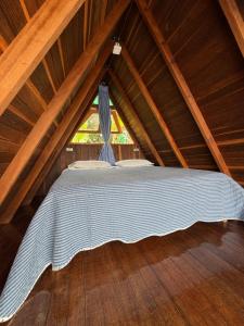 a bed in a attic room with a window at Cabaña en Jericó in Jericó