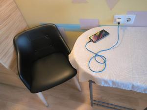 a table with a black chair next to a table with a lamp at Arsenal in Daugavpils