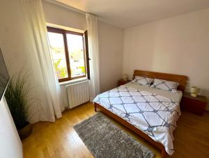 a bedroom with a bed and a window at Apartment Dalmare in Biograd na Moru