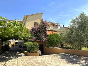 a house with trees in front of it at Apartment Dalmare in Biograd na Moru