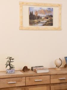 a painting hanging on a wall above a wooden dresser at Villa Valeria in San Floro +35 photos