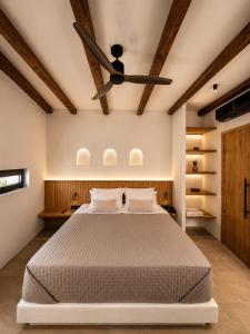 a bedroom with a bed with a ceiling fan at ARC suites in Mylopotas +47 photos