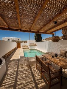 a patio with a table and a swimming pool at ARC suites in Mylopotas
