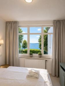 a bedroom with a bed and a large window at Oceanview Residences Lauterbach Rügen Ostsee erste Reihe in Putbus