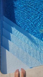a pair of feet standing next to a swimming pool at Apartment with private pool in Njivice