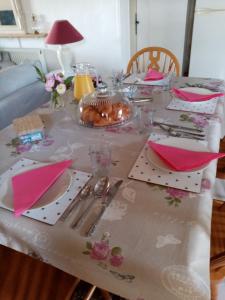a table with pink napkins and utensils on it at Le Tilleuil in Combiers