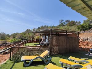a group of chairs on a deck with a house at The Place in Albufeira
