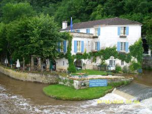 a house on an island in the water next to a river at Le Tilleuil in Combiers