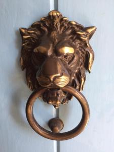 a bronze door knocker of a lion with a handle at Birgu Studio Maisonette in Birgu