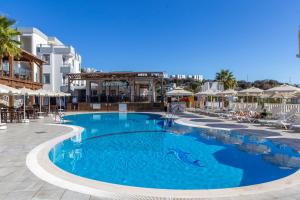 a large swimming pool with chairs and umbrellas at a resort at Bodrum Fora Holiday Resort in Bodrum City