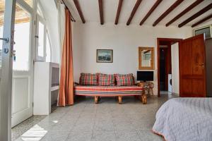 a living room with a couch and a bed at House La Pennata - sea view in Malfa
