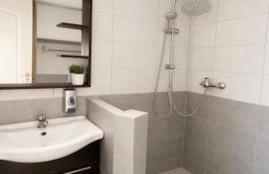 a bathroom with a sink and a shower with a sink at Holdfény apartman in Siófok