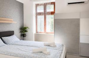 a bedroom with two beds and a window at Holdfény apartman in Siófok