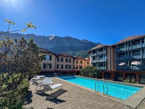 a hotel with a swimming pool and some buildings at Double Room by Interlaken. Parking in Därligen