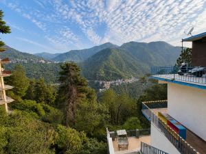 a balcony of a building with a view of mountains at Cross Hill House Mussoorie in Mussoorie